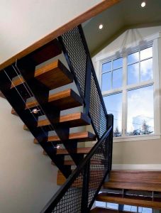 A staircase with metal and wood steps next to a window.