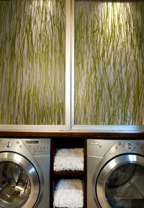 A washer and dryer in a room with green grass on the walls.