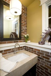 A bathroom with brick walls and a mirror