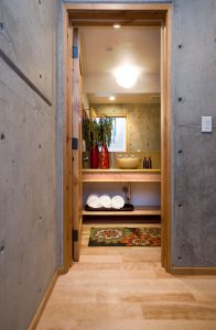 A bathroom with a wooden floor and concrete walls.