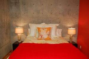 A bed with two lamps and a red blanket