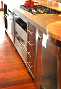 A kitchen with wooden floors and stainless steel cabinets.