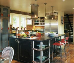 A kitchen with stainless steel appliances and black cabinets.