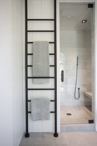 A towel rack with three towels hanging on it.