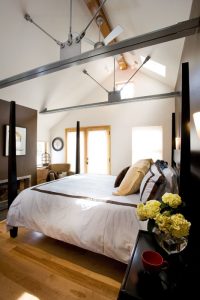 A bedroom with four poster bed and vaulted ceiling.