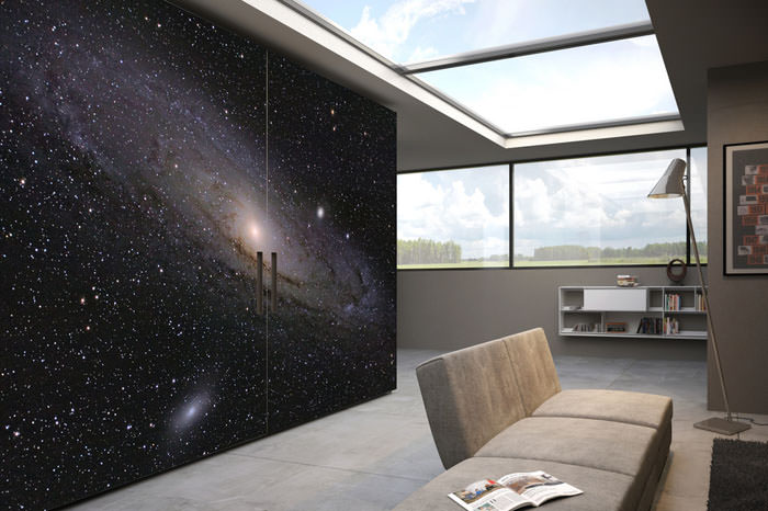 A room with a large wall mural of the milky way.