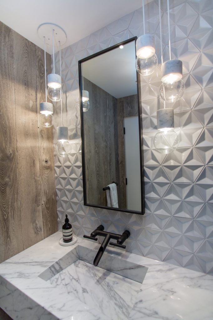 A bathroom with a sink, mirror and lights.